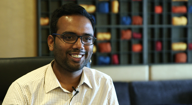 Preview image for the video "Indus Action: Enabling sustained access to legislated rights for disadvantaged families" - Close up headshot of a young Indian man with short hair and a white collared shirt.