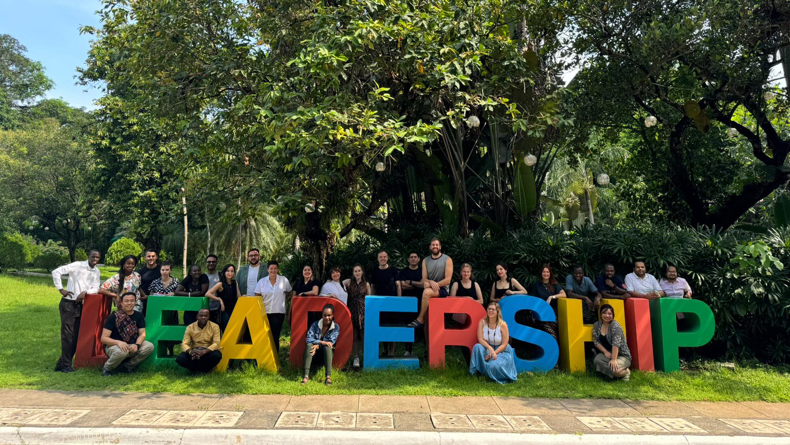 Preview image for the video "Education in Emergencies System Leaders Community". Preview image for the video "Education in Emergencies System Leaders Community" - A diverse group of young adults stands around a 3D multi-colored sign that says Leadership.