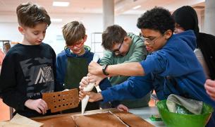 Students assemble a gingerbread model of their school
