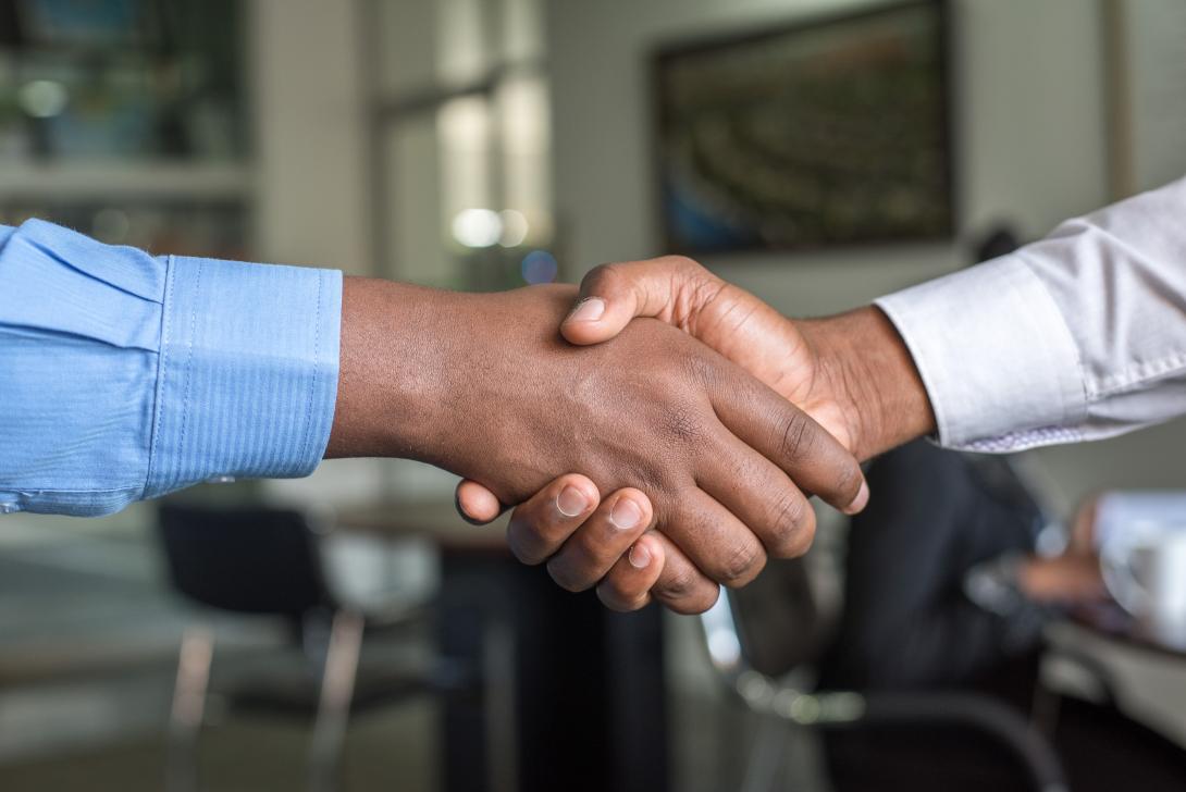 Two brown skinned hands, shaking hands