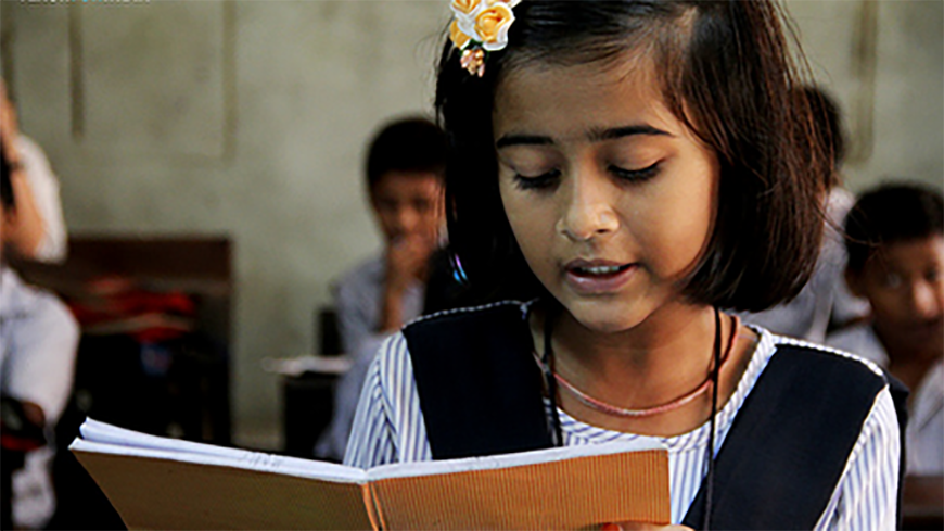 A young indian girl reads a book